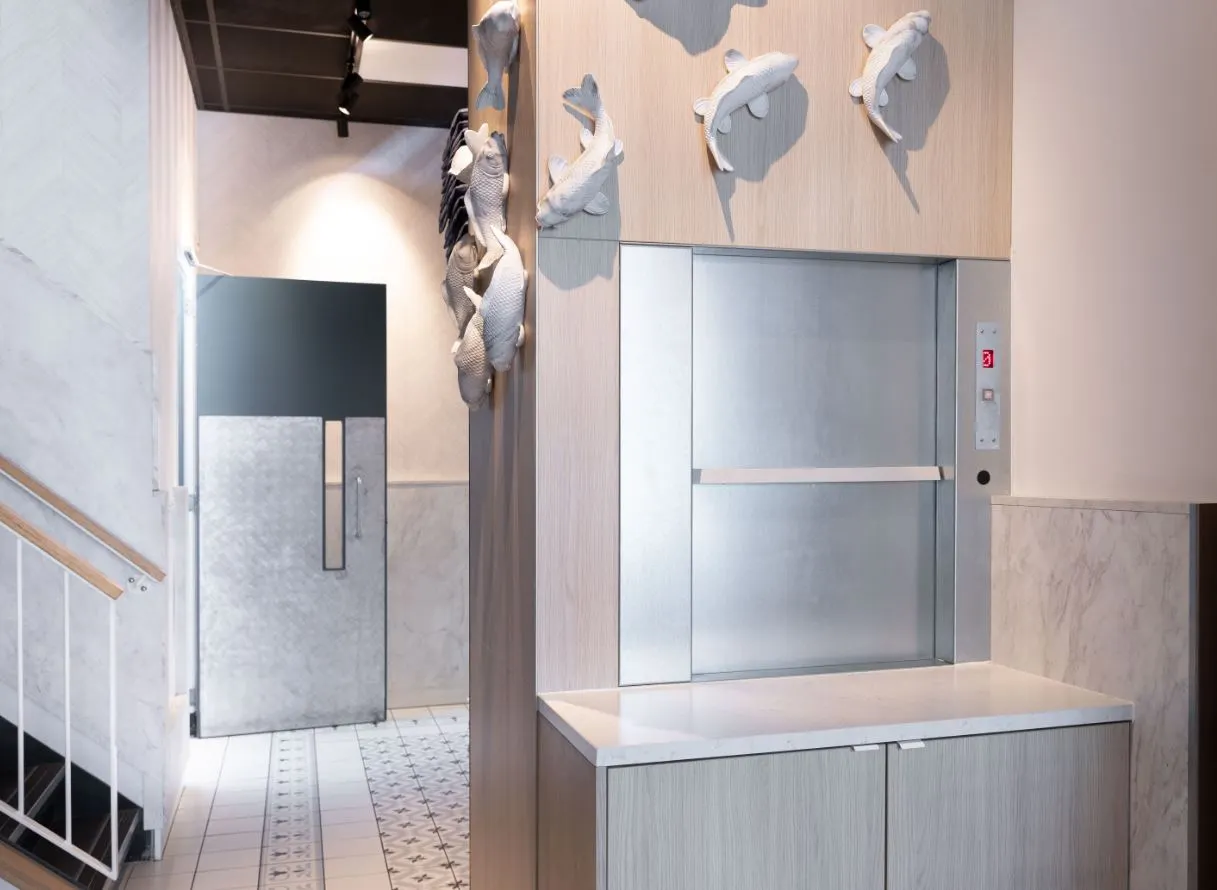Moderne ruimte met een lift, visdecoraties en een betegelde vloer.